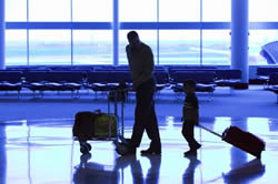 Passengers walking down an airport concourse.