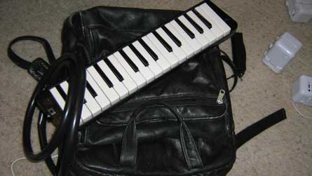 the instrument is a pump in a backpack with a tube leading to a melodica